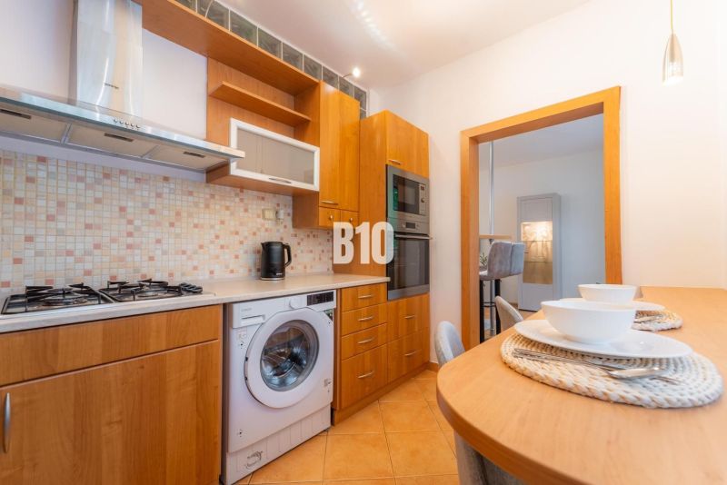 Küche mit Gasherd, Geschirrspüler und Bartisch in einer 2-Zimmer-Wohnung.