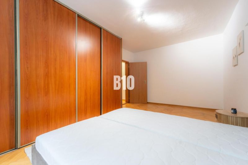 Schlafzimmer mit großem Schrank in einer 2-Zimmer-Wohnung, Boden mit Holzdekor.