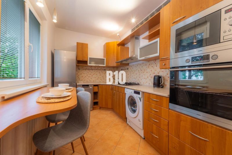 Küche in einer 2-Zimmer-Wohnung mit Holzelementen und Geräten.