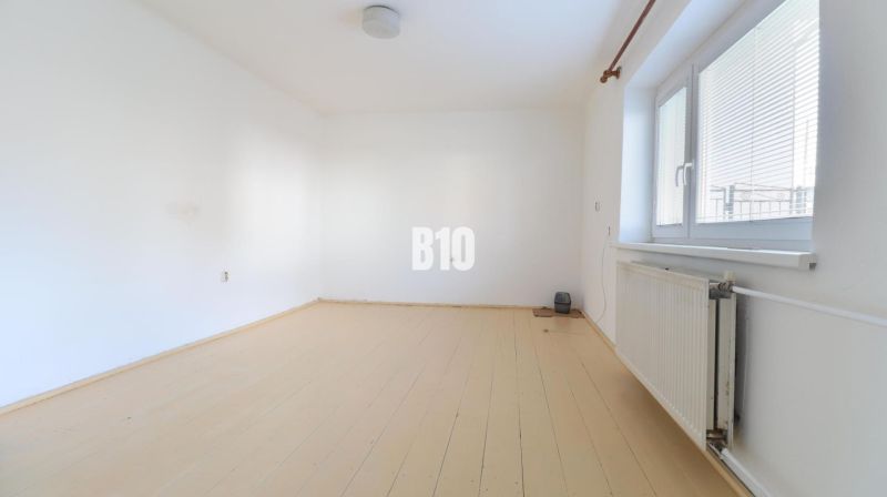 Ein geräumiger Raum mit weißen Wänden und hellem Boden in einem Einfamilienhaus.