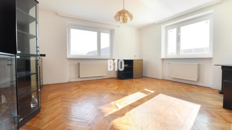 Ein geräumiges Zimmer mit einer Glasvitrine und einem Boden in Holzoptik in einem Einfamilienhaus.