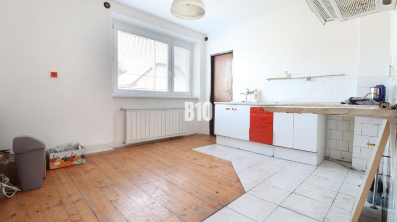 Küche in einem Einfamilienhaus mit Holzboden und weißen Wänden.