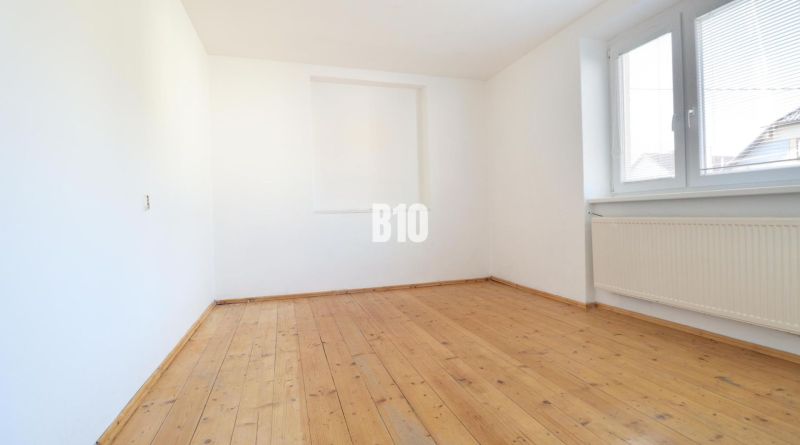 Ein leerer Raum mit Holzboden in einem Einfamilienhaus.