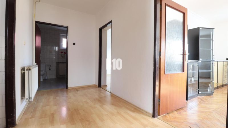Flur mit Holzboden und Blick auf das Badezimmer in einem Einfamilienhaus.