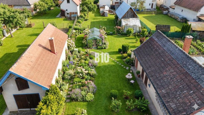 Luftaufnahme eines Gartens bei einem Einfamilienhaus in Turany, mit Rasen und Pavillon.