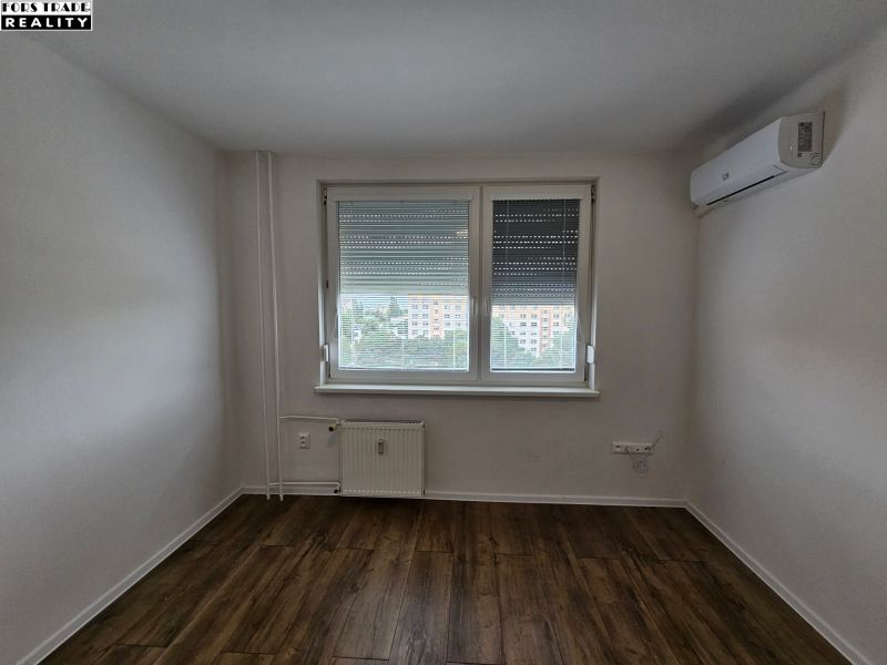 Einzimmerwohnung mit Holzboden, Klimaanlage und Heizkörper.