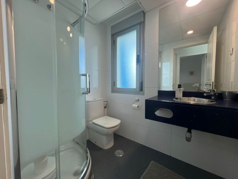 Badezimmer mit Toilette, Dusche und Waschbecken in einer Ferienwohnung.