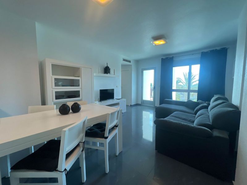 Esstisch mit Stühlen und Sofa, Ferienwohnung, Boden mit Holzdekor.