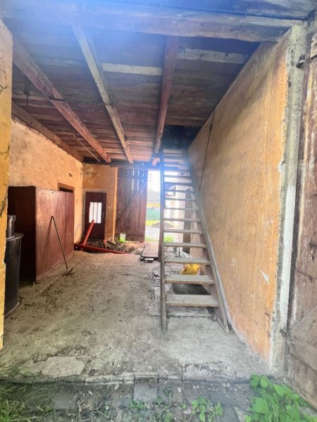 Lagerraum in einem Einfamilienhaus mit Holztreppe und Lehmboden.