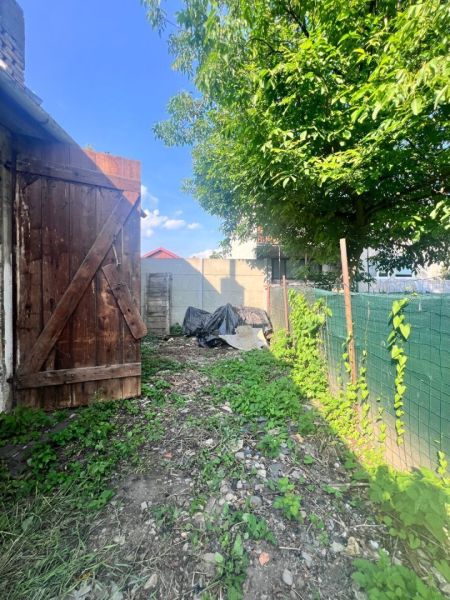 Der Garten des Einfamilienhauses in Brehoch, Nová Baňa, mit einem Holztor und einem Baum.