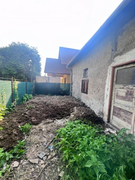 Älteres Einfamilienhaus in Brechy, Nová Baňa, Bezirk Žarnovica, mit einem Lehmbodenhof und Vegetation.