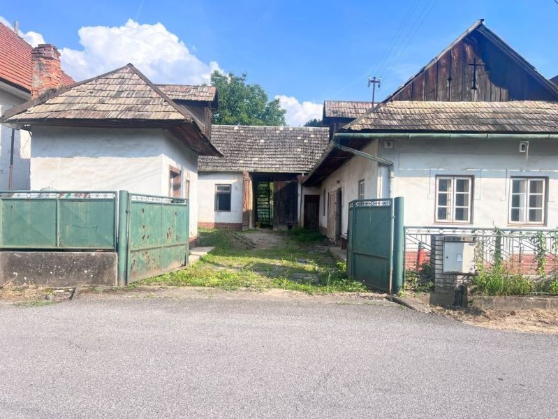 Ein Einfamilienhaus in Brechy, Nová Baňa, Bezirk Žarnovica, mit einem Blechtor und einem Schindeldach.