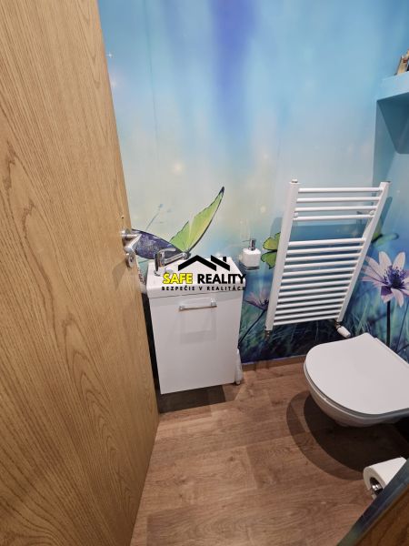 Badezimmer mit Naturmotiv und Boden mit Holzdekor in einer 3-Zimmer-Wohnung.