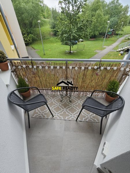 Der Balkon der 3-Zimmer-Wohnung bietet Blick auf Grünflächen und einen Kinderspielplatz.