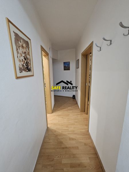 Ein Flur mit hellen Wänden und einem Boden in Holzoptik in einer 3-Zimmer-Wohnung.