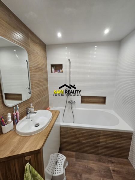 Badezimmer in einer 3-Zimmer-Wohnung mit Badewanne und Holzdekor.