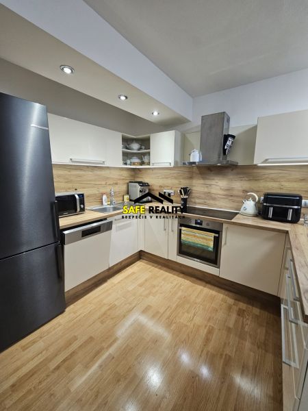Küche in einer 3-Zimmer-Wohnung mit Holzboden und modernen Geräten.