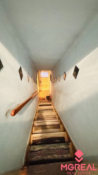 Ein enger Treppenaufgang mit Wänden, die mit Bildern in einer 3-Zimmer-Wohnung dekoriert sind.