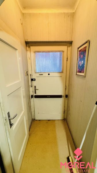 Eingangsflur in einer 3-Zimmer-Wohnung mit älteren Türen und hellen Wänden.