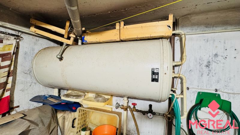 Boiler im Technikraum einer 3-Zimmer-Wohnung, Rohrleitungen, Schläuche, Wände.