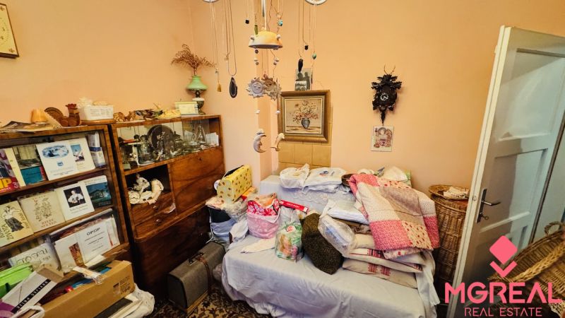 Ein Zimmer in einer 3-Zimmer-Wohnung mit einem Bett, Decken und einem Bücherregal mit Büchern.