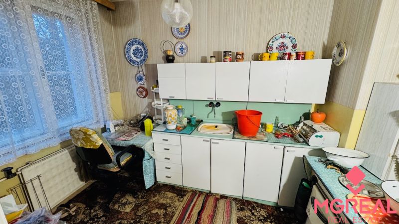 Küche in einer 3-Zimmer-Wohnung mit Vorhängen, Spitzenverzierungen und antiken Möbeln.