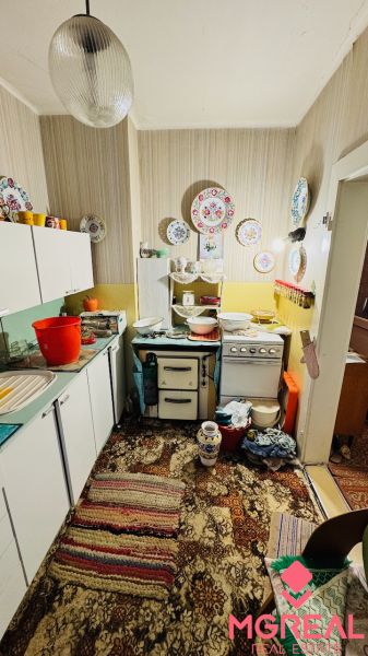 Küche mit Vintage-Dekor in einer 3-Zimmer-Wohnung und einem Teppich mit buntem Muster.