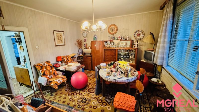 Ein Zimmer voller Vintage-Möbel und Dekorationen in einer 3-Zimmer-Wohnung mit Holzboden.