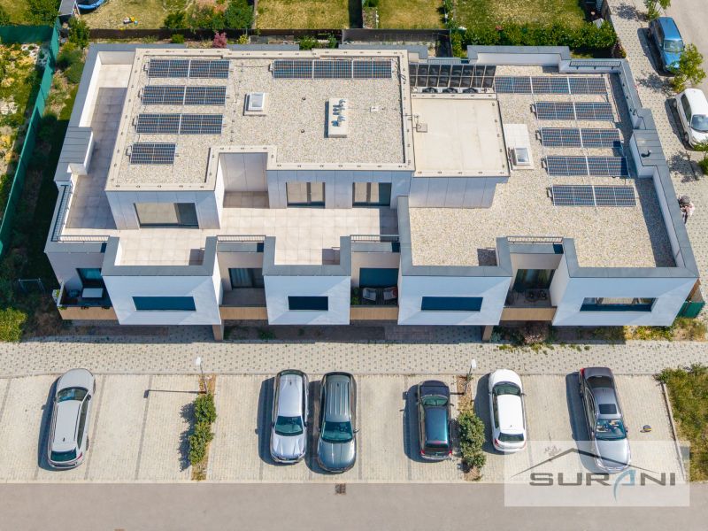 Das Gebäude in der Mesačná-Straße in Hviezdoslavov mit Solarpanelen und geparkten Autos.