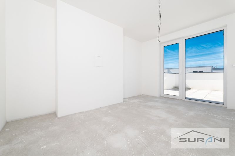 Unmöbliertes Zimmer in einer 3-Zimmer-Wohnung mit französischem Fenster und Blick auf die Terrasse.