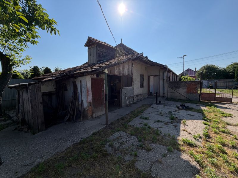 Einfamilienhaus in Nesvady mit beschädigtem Dach und sonnigem Hof.