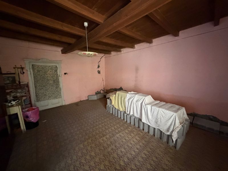 Ein Raum in einem Einfamilienhaus mit antiker Beleuchtung und einer Balkendecke.
