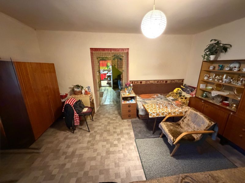 Wohnzimmer in einem Einfamilienhaus mit antiken Möbeln und Sesseln, Boden mit Holzdekor.
