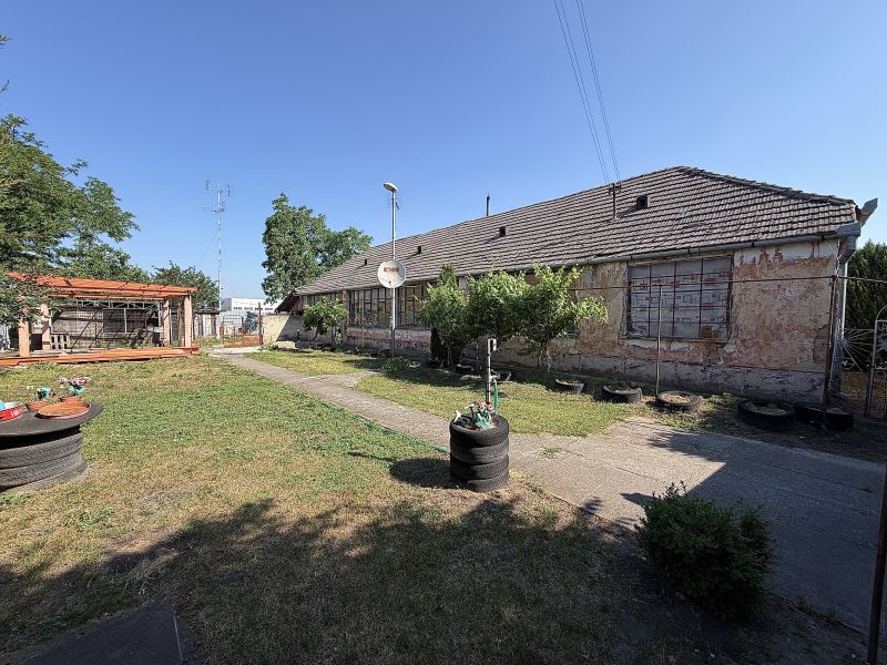 Ein Einfamilienhaus in Nesvady mit einer ungepflegten Fassade, einer Holzpergola und einem gepflegten Garten.