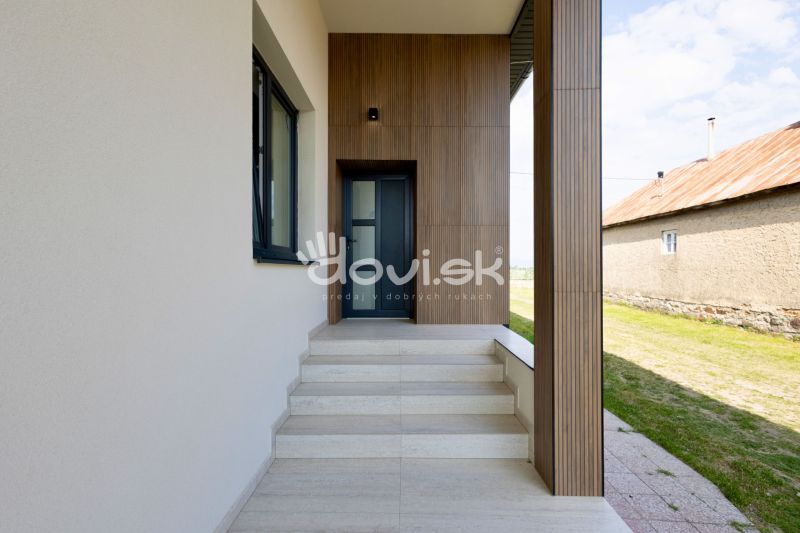 Eingangsbereich in einem Einfamilienhaus in Zemplínska Široká mit Holzdekor an der Fassade.