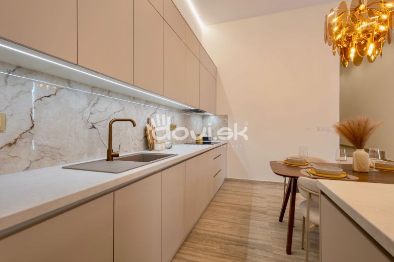 Küche mit eleganter Arbeitsplatte, modernem Spülbecken und dekorativer Beleuchtung im Einfamilienhaus.