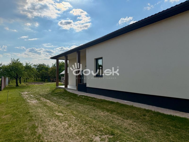 Das Äußere eines Einfamilienhauses in Zemplínska Široká, umgeben von Rasen und Bäumen.