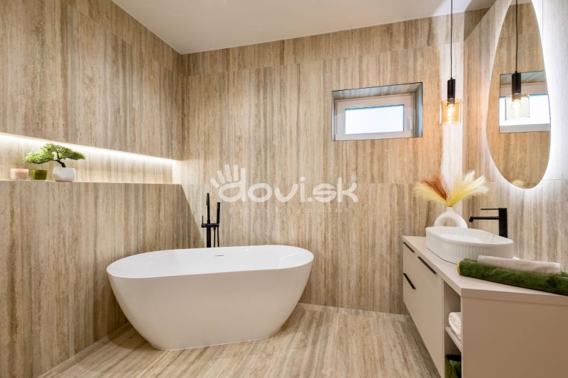 Badezimmer in einem Einfamilienhaus mit freistehender Badewanne, Holzdekor und Hängelampen.