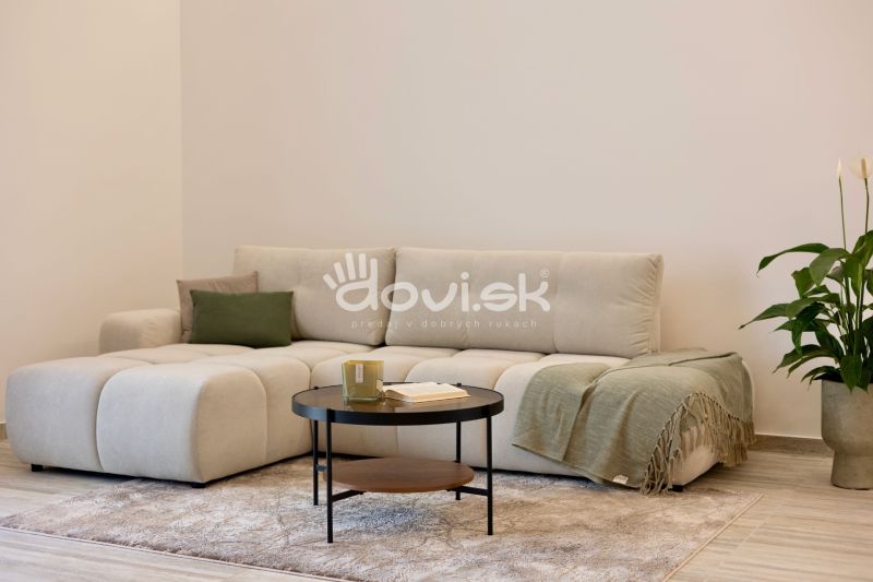 Helles Interieur mit bequemer Couch, Couchtisch und Boden mit Holzdekor.