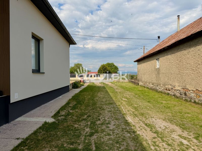 Ein Einfamilienhaus in Zemplínska Široká mit einem Rasen zwischen den Gebäuden und einem gepflegten Gehweg.