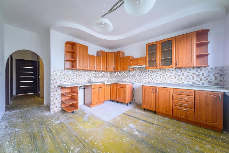 Küche mit Holzschränken und Fliesenverkleidung in einer 3-Zimmer-Wohnung.