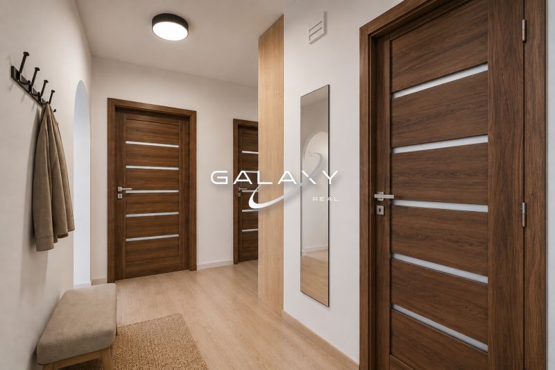 Flur mit Holzboden, Spiegel und skandinavischen Möbeln in einer 3-Zimmer-Wohnung.