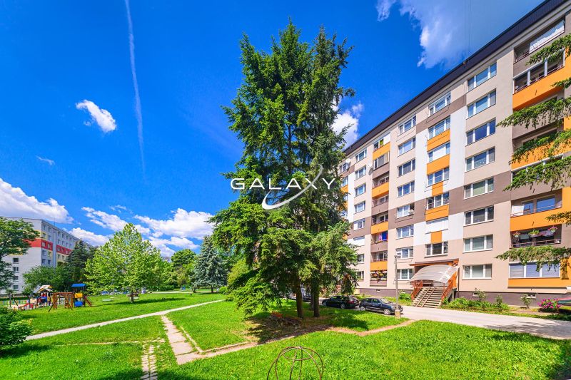Wohnsiedlung Rimava in Rimavská Sobota mit einem Plattenbau, einem Kinderspielplatz und Grünflächen.