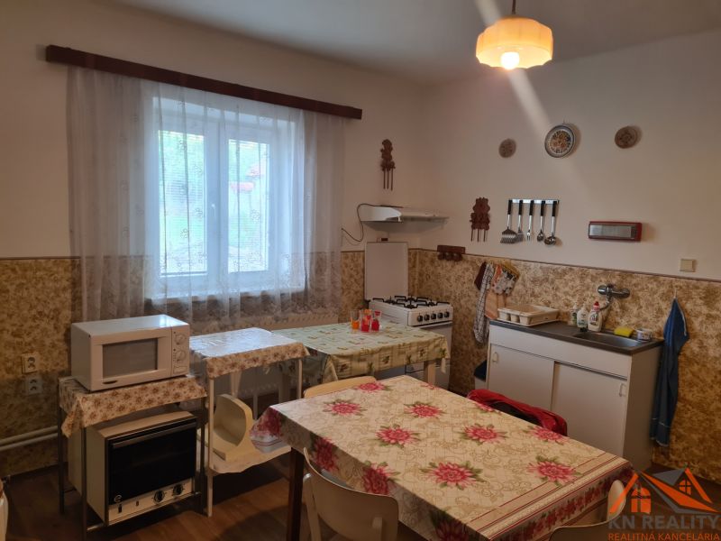 Küche in einem Einfamilienhaus mit Mikrowelle, Herd, Tisch und Spüle.