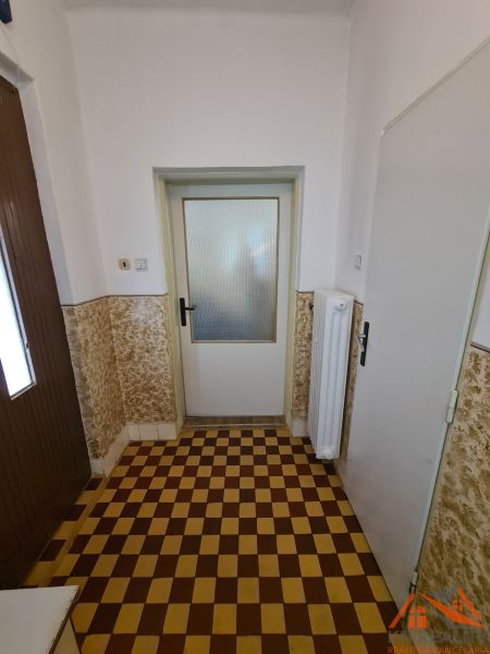 Fliesen mit Schachbrettmuster im Innenraum eines Einfamilienhauses mit weißen Wänden.