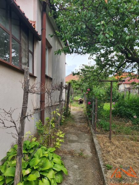 Ein Garten neben einem Einfamilienhaus in Dulovce mit einem Weg und Pflanzen.