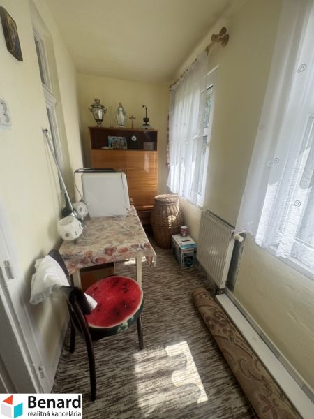 Izba in einem Einfamilienhaus mit Teppich, Möbeln und Dekorationen.