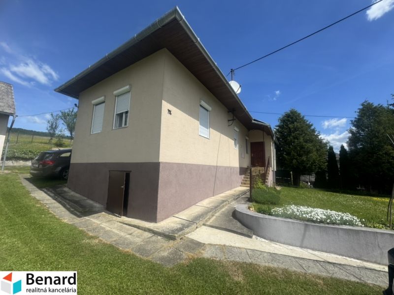 Ein Einfamilienhaus in Orlov mit Zufahrtsstraße, Auto und gepflegtem Garten.