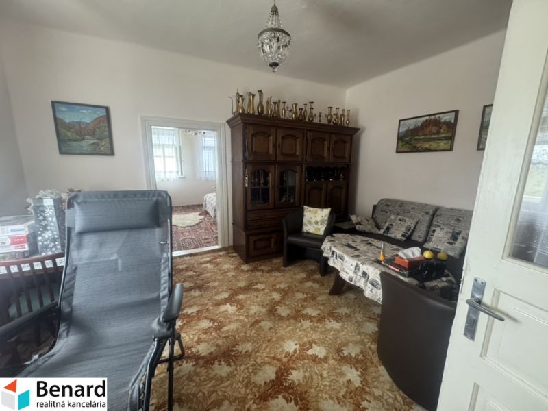 Ein Zimmer in einem Einfamilienhaus mit einem reich verzierten Schrank und bequemen Sitzgelegenheiten.