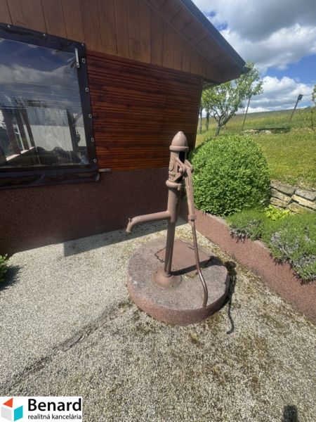 Ein Einfamilienhaus in Orlové mit einer alten Wasserpumpe auf einem Kiesuntergrund.